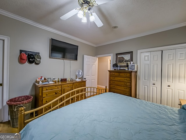 bedroom with a textured ceiling, a closet, ceiling fan, and ornamental molding