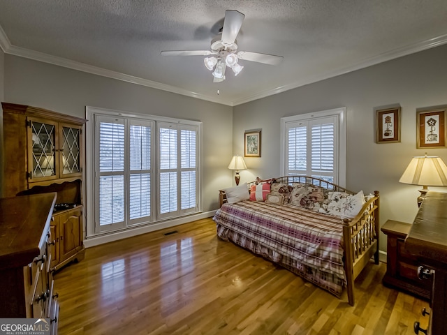 bedroom with multiple windows, ornamental molding, and hardwood / wood-style flooring