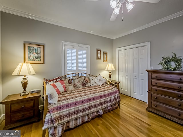 bedroom featuring light hardwood / wood-style flooring, crown molding, and a closet