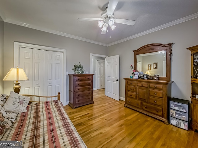 bedroom with ceiling fan, light hardwood / wood-style flooring, crown molding, and a closet