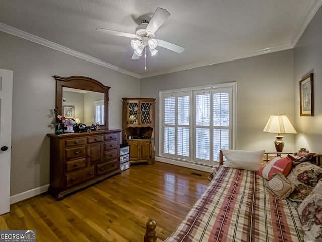 bedroom featuring hardwood / wood-style floors, crown molding, and ceiling fan