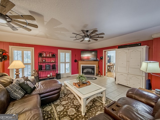 tiled living room featuring a textured ceiling, a wealth of natural light, and ceiling fan