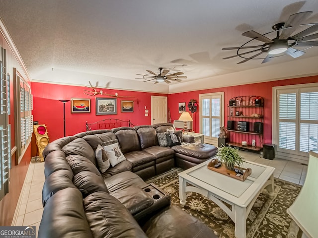 tiled living room with ceiling fan, a textured ceiling, and a wealth of natural light