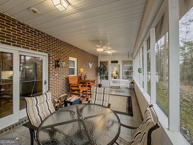 sunroom featuring ceiling fan and wood ceiling