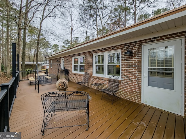 wooden terrace featuring an outdoor fire pit