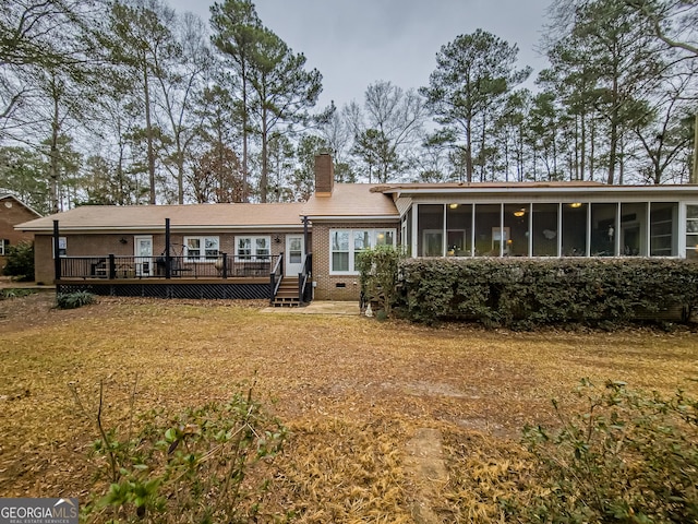 rear view of house with a deck and a sunroom