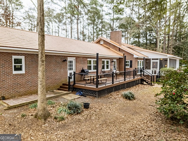 rear view of property with a deck and a sunroom