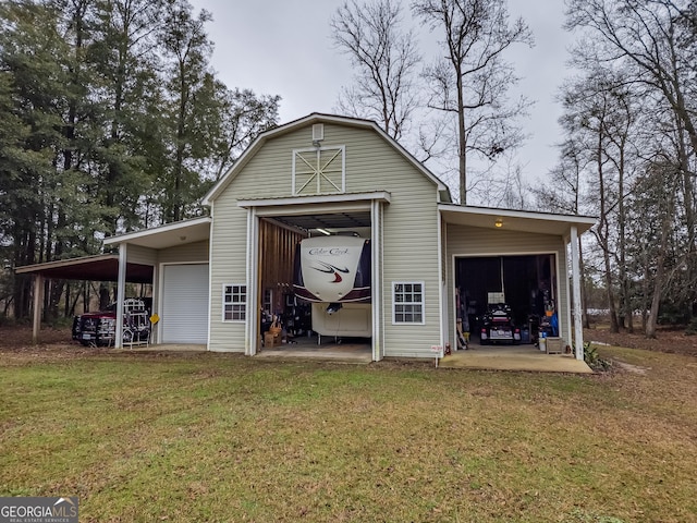 back of property with a garage, a lawn, and a carport