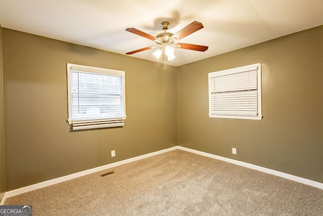 carpeted spare room with ceiling fan