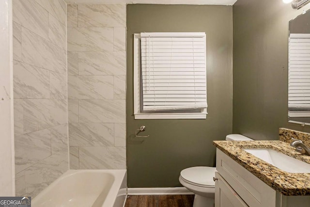 bathroom with vanity, a bathtub, toilet, and hardwood / wood-style flooring