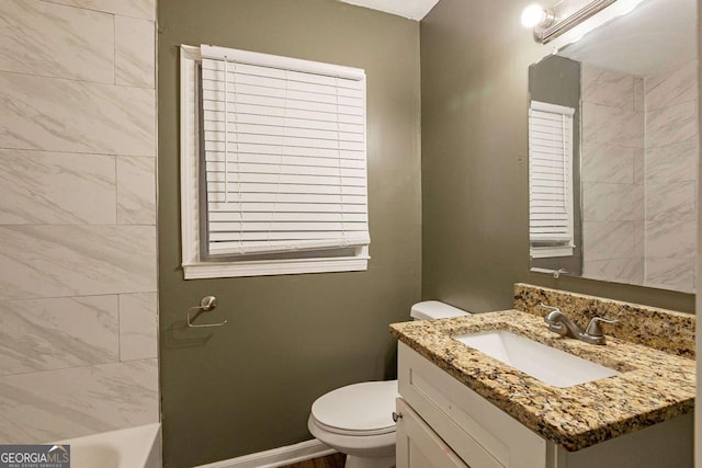 bathroom featuring vanity, toilet, and a washtub