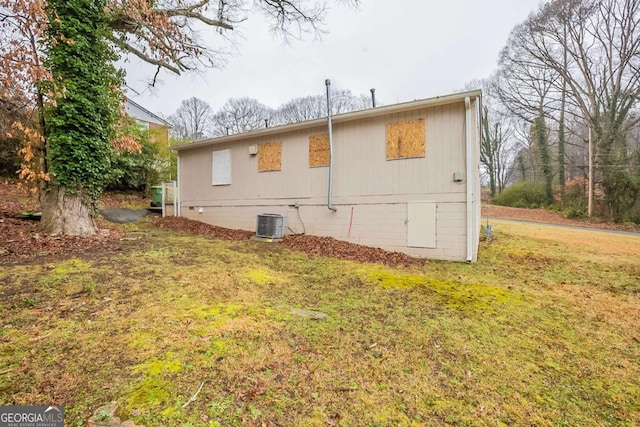 back of house with a yard and central air condition unit