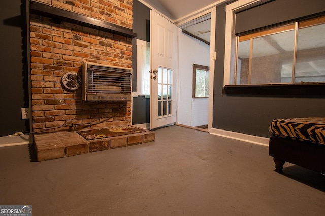 unfurnished living room featuring heating unit and concrete floors