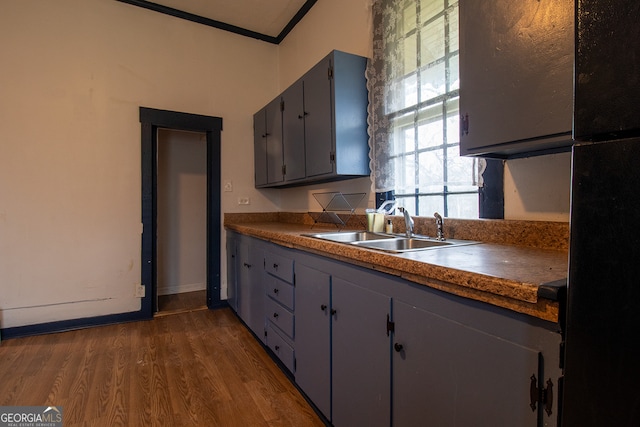 kitchen with sink, crown molding, gray cabinetry, black refrigerator, and dark hardwood / wood-style floors