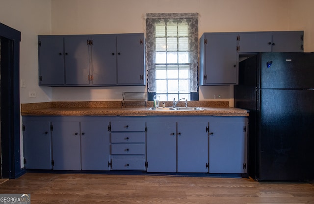 kitchen featuring black refrigerator, sink, and dark hardwood / wood-style floors