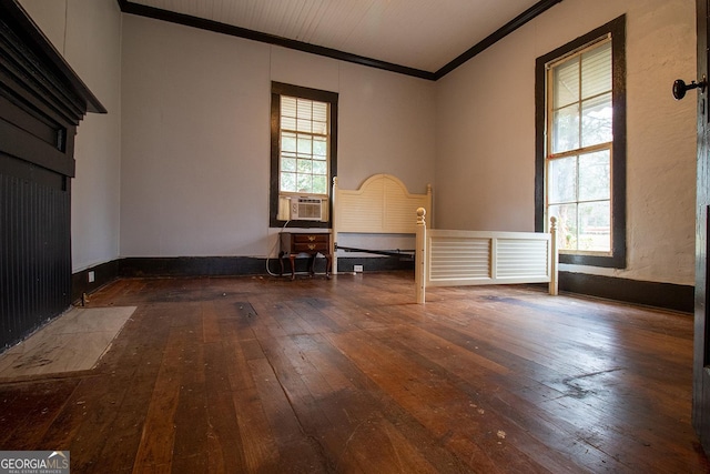 empty room with crown molding, a healthy amount of sunlight, hardwood / wood-style floors, and cooling unit