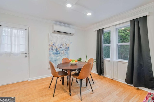 dining space featuring ornamental molding, a wall unit AC, and light hardwood / wood-style flooring