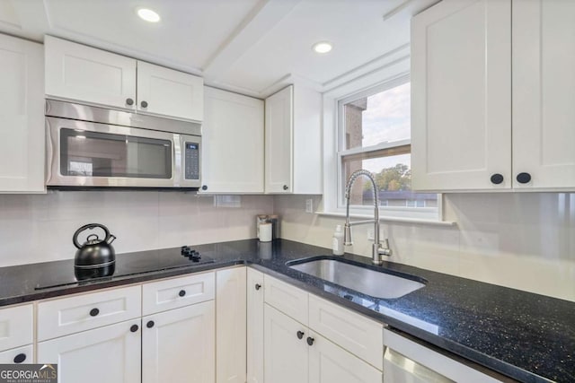 kitchen featuring appliances with stainless steel finishes, sink, decorative backsplash, and white cabinets