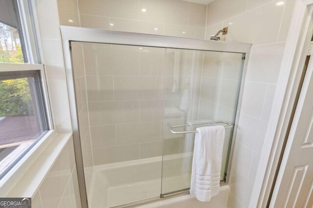 bathroom featuring bath / shower combo with glass door