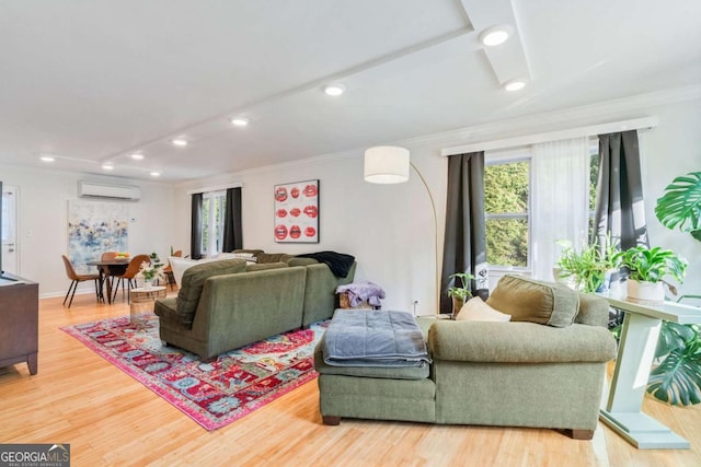 living room with hardwood / wood-style flooring, ornamental molding, and a wall unit AC