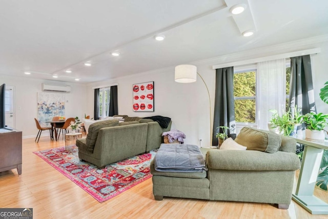 living room with hardwood / wood-style floors, ornamental molding, a wall unit AC, and a healthy amount of sunlight