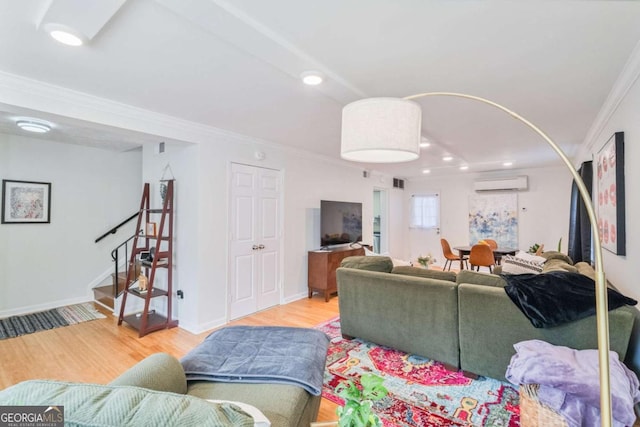 living room with crown molding, a wall mounted AC, and light wood-type flooring