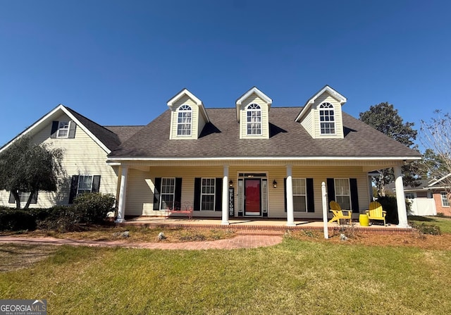 cape cod house featuring a porch, a front yard, and a shingled roof