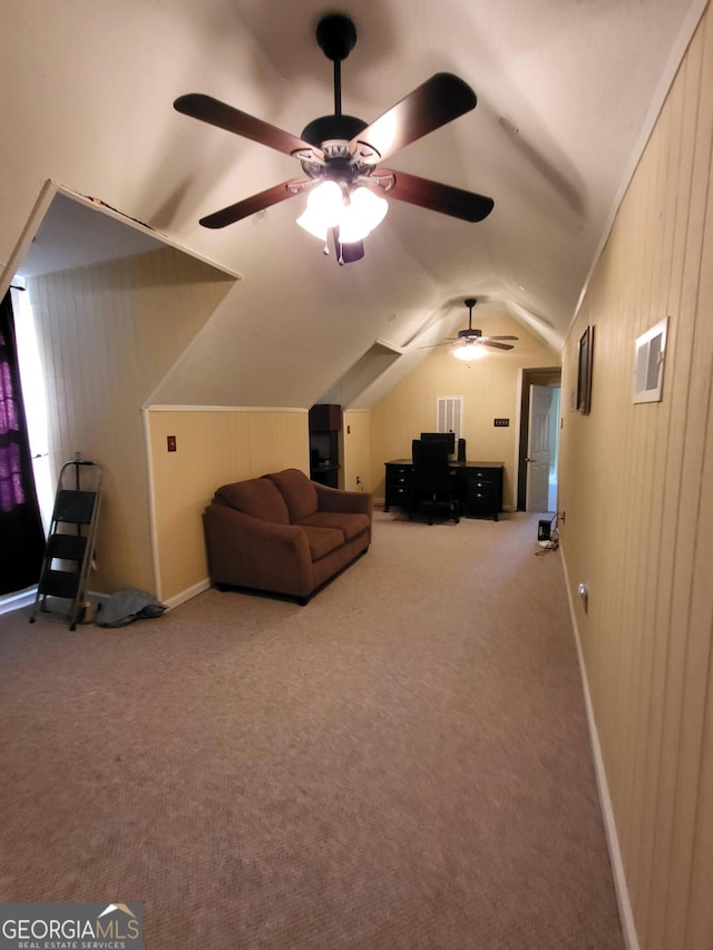 interior space with lofted ceiling, carpet flooring, ceiling fan, and wood walls