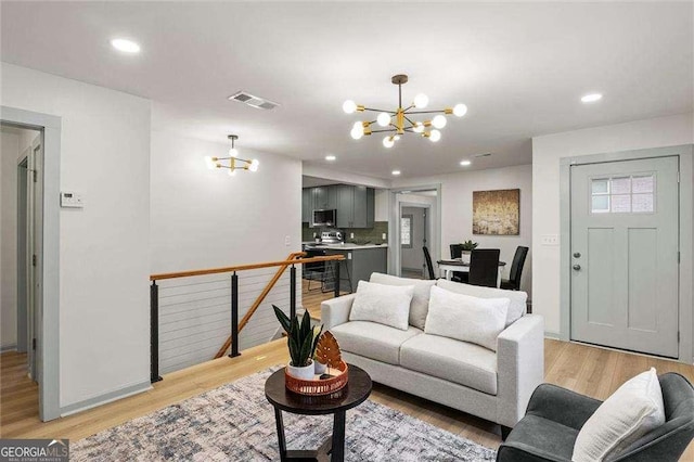 living room featuring a chandelier and light wood-type flooring