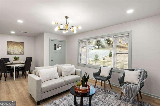 living room with an inviting chandelier and light hardwood / wood-style flooring