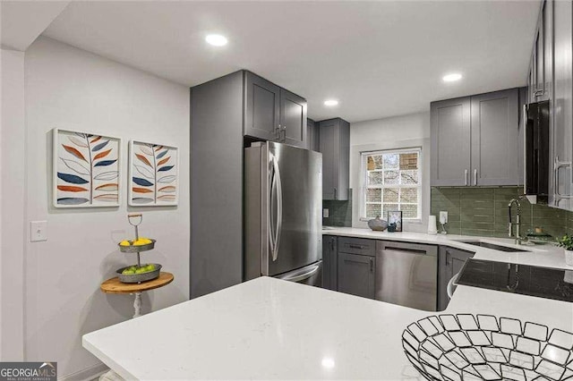 kitchen featuring tasteful backsplash, sink, stainless steel appliances, and kitchen peninsula