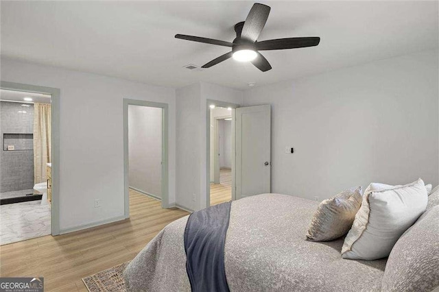 bedroom with ensuite bathroom, ceiling fan, and light hardwood / wood-style floors