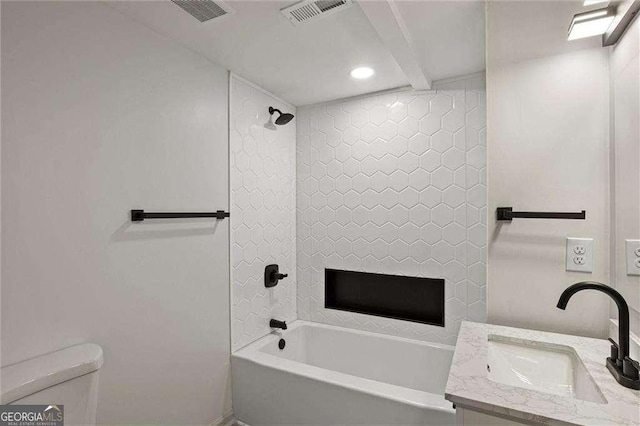 full bathroom featuring tiled shower / bath combo, vanity, and toilet