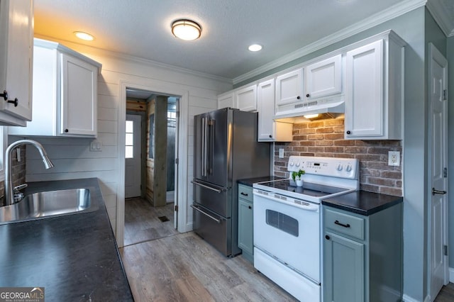 kitchen featuring sink, high end fridge, white cabinets, and white range with electric stovetop