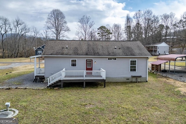 rear view of property with a carport, a deck, and a lawn