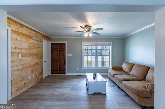 living room with crown molding, ceiling fan, a textured ceiling, and dark hardwood / wood-style flooring