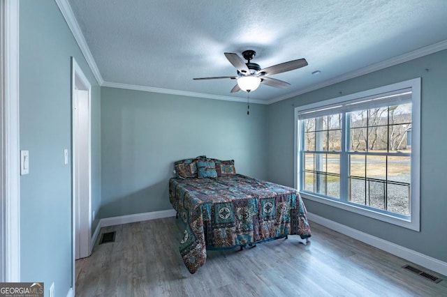 bedroom with crown molding, ceiling fan, hardwood / wood-style floors, and a textured ceiling