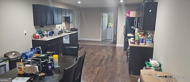 kitchen featuring dark hardwood / wood-style flooring, sink, and black fridge