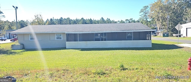 view of front of house featuring a sunroom and a front yard