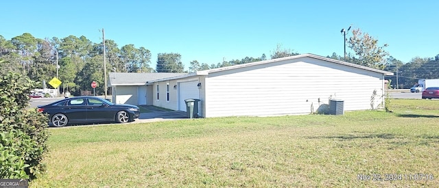 view of side of home with a garage, central air condition unit, and a lawn