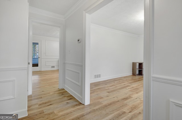 hall with crown molding, a textured ceiling, and light hardwood / wood-style flooring