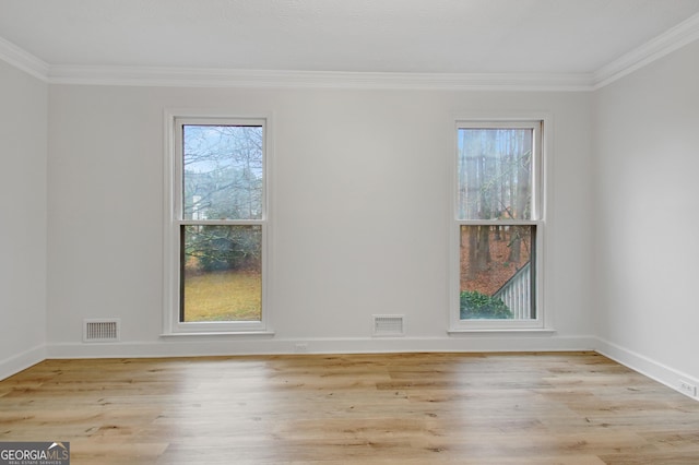 spare room featuring crown molding and light wood-type flooring