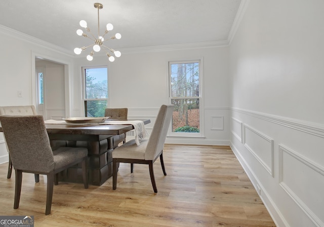 dining room with crown molding, a chandelier, and light hardwood / wood-style flooring