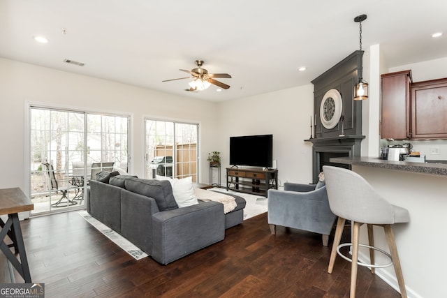 living room with ceiling fan and dark hardwood / wood-style flooring