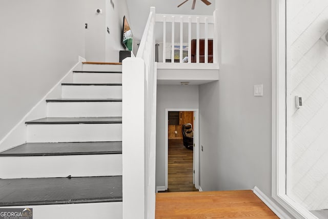 stairway featuring a high ceiling and wood-type flooring