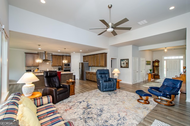 living room with dark wood-type flooring and ceiling fan