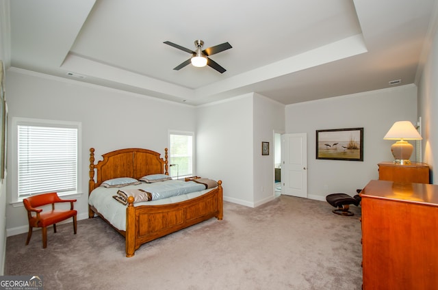 bedroom with crown molding, a tray ceiling, and carpet floors