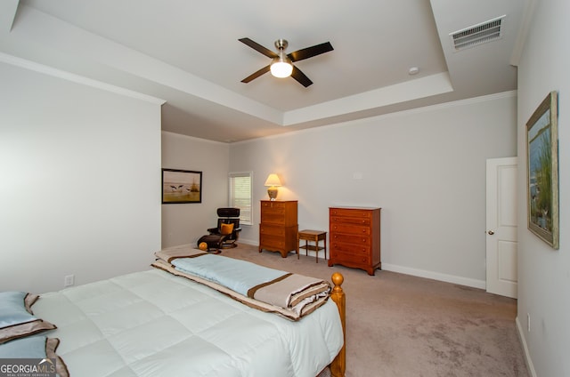 carpeted bedroom featuring crown molding, ceiling fan, and a tray ceiling