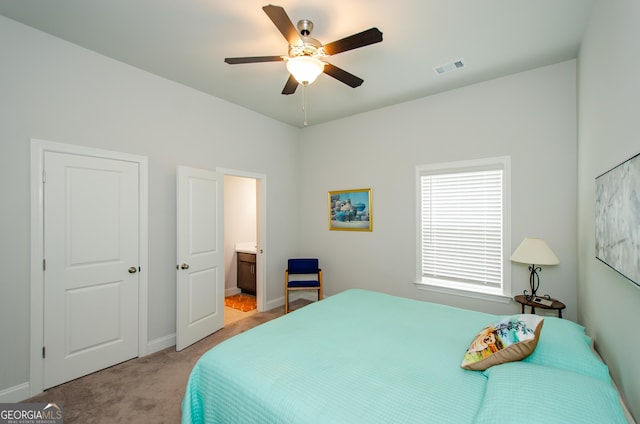 bedroom featuring connected bathroom, light colored carpet, and ceiling fan