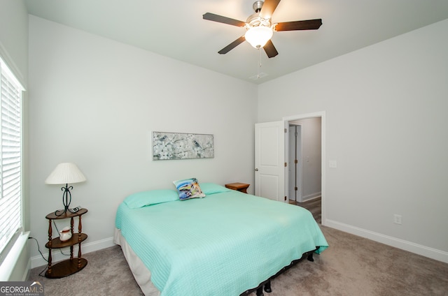 bedroom with ceiling fan, light colored carpet, and multiple windows